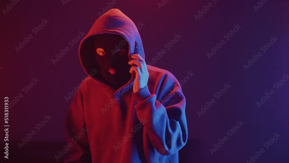 phone scammer in a mask speaks on the phone phone scammer in a mask speaks on the phone