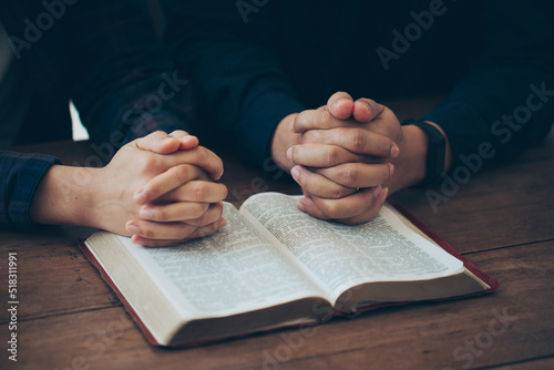 Couples holding hands together and praying on the holy bible. believe in goodness. online group worship, world day of prayer, international day of prayer, worship and religion. thankful, trust concept