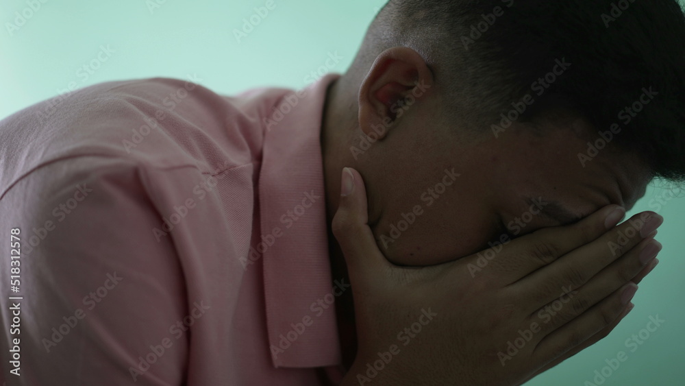 Depressed man in crisis. Sad unhappy person covering face suffering from mental illness Depressed man in crisis. Sad unhappy person covering face suffering from mental illness