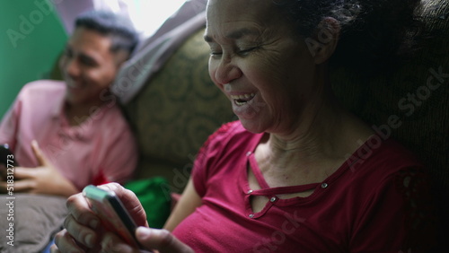 A senior woman talking on phone laughing and smiling. A hispanic latin south american older person using cellphone