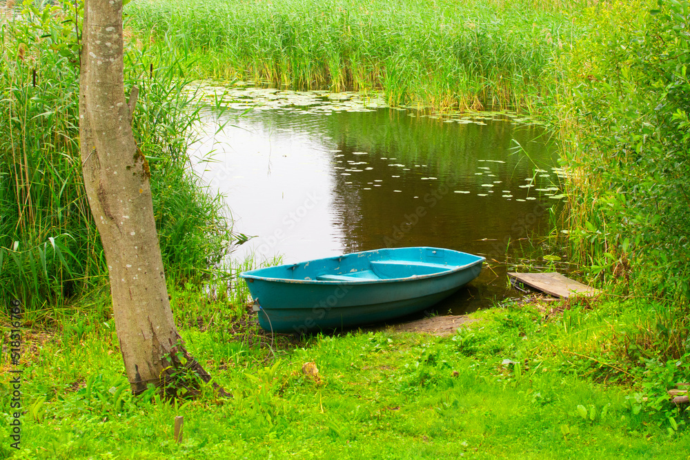 Beautiful summer landscape. Boat on the lake shore