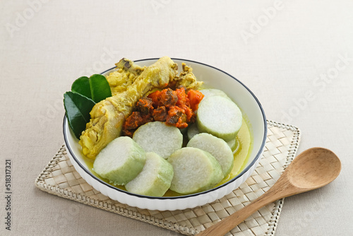 Lontong Opor, Indonesian traditional breakfast or a Eid menu. Opor made from chicken cooked with coconut milk and spices. Its usually served to celebrate Eid Adha and Eid Fitr. Selective focus.
 photo