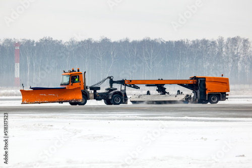 Fotografija Snowplow truck cleans runway on airfield during snowfall