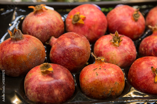 Seasonal fruits at the agricultural market, pomegranates