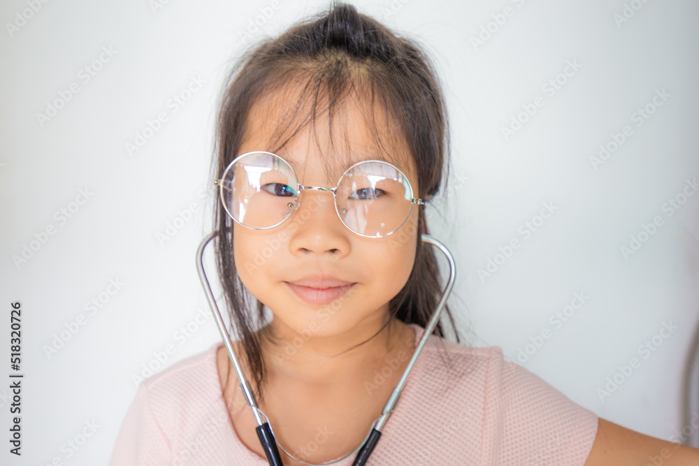 Adorable glasses child girl playing with doctor costume with sthetoscope Adorable glasses child girl playing with doctor costume with sthetoscope