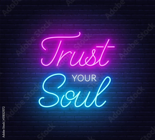 Trust your soul neon quote on a brick wall.