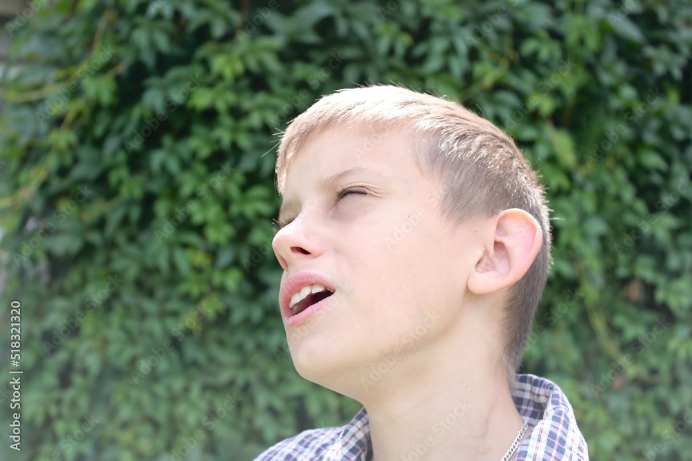 the boy under the summer sun looks with admiration and surprise at the sky