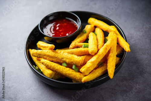 Crispy fried baby corn pakoda, pakora  or Baby corn fritters served with ketchup, Indian food photo