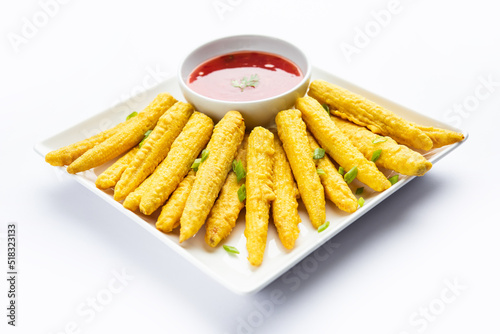 Crispy fried baby corn pakoda, pakora  or Baby corn fritters served with ketchup, Indian food photo