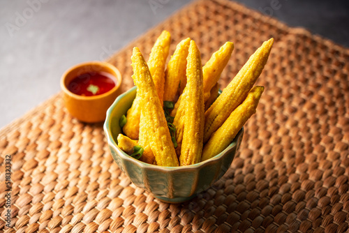 Crispy fried baby corn pakoda, pakora  or Baby corn fritters served with ketchup, Indian food photo