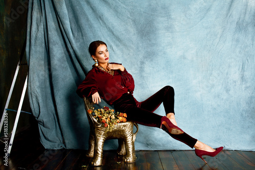 beauty rich brunette woman in luxury interior near empty frames, wearing fashion clothes, lifestyle people concept