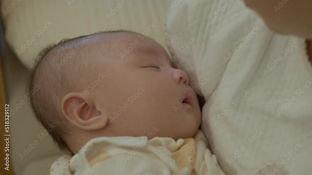 The face of a baby sleeping in the mother's arms. Asian baby. The face of a baby sleeping in the mother's arms. Asian baby.