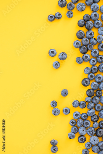 Colorful fruit pattern of blueberries on yellow background