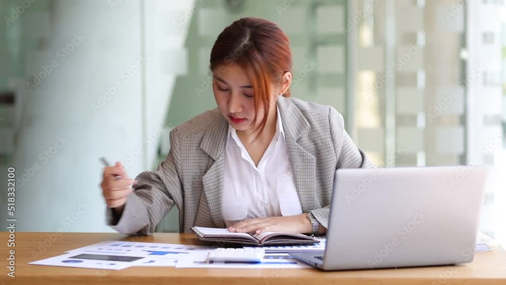 Business woman working in finance is calculating budget by calculator in bank office working while working on laptop and audit documents analyzing financial for accounting. Business woman working in finance is calculating budget by calculator in bank office working while working on laptop and audit documents analyzing financial for accounting.