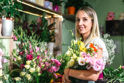 Beautiful girl florist working in flower shop. Making decorations and arrangements. Flowers delivery, creating order. Small business. .