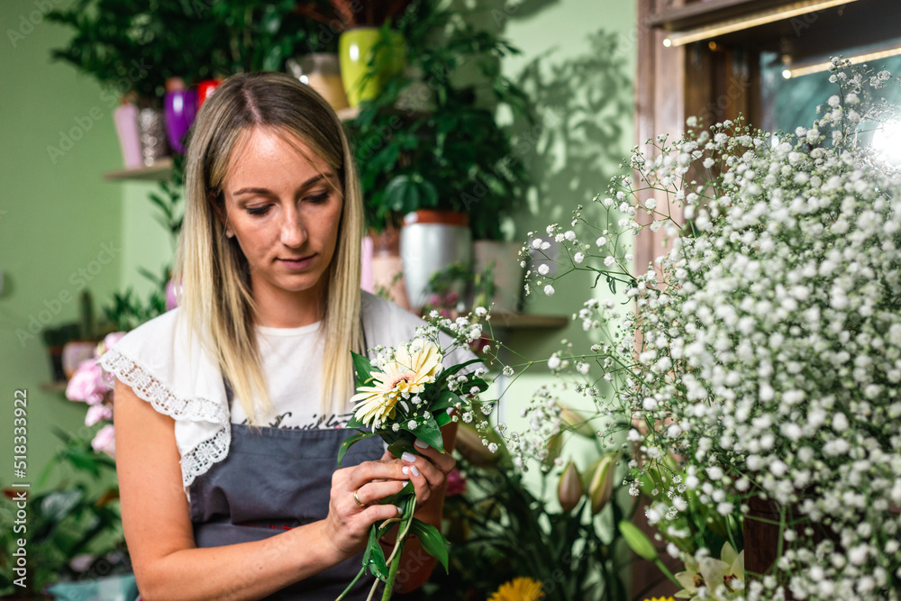 Beautiful girl florist working in flower shop. Making decorations and arrangements. Flowers delivery, creating order. Small business. .