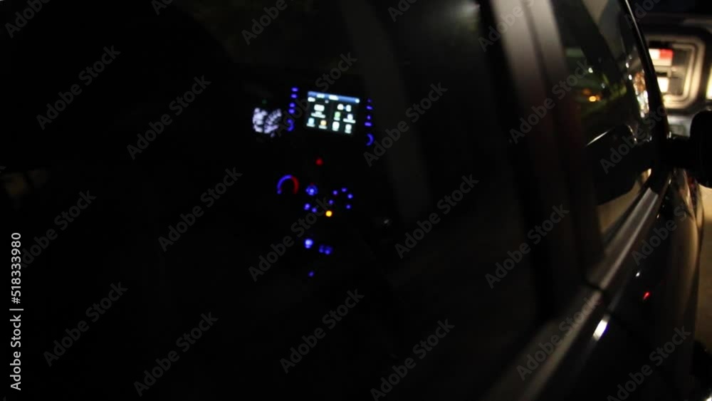 Security guard is patrolling a construction site with emergency vehicle lighting on at night, the security sign on the back of his uniform is reflected on the window. Security guard is patrolling a construction site with emergency vehicle lighting on at night, the security sign on the back of his uniform is reflected on the window.