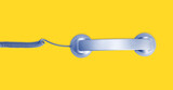 Telephone handset isolated on yellow background. Contact us banner. Top view