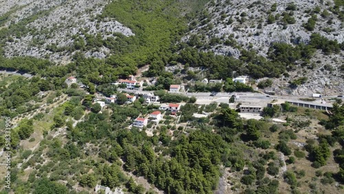 small village on the Croatian coast (Dalmatia) on a coastal road with some moving cars, sunny nice weather photo