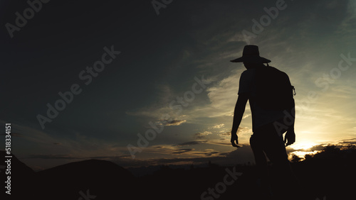 man traveler walking at sunset through the desert, silhouette of a man