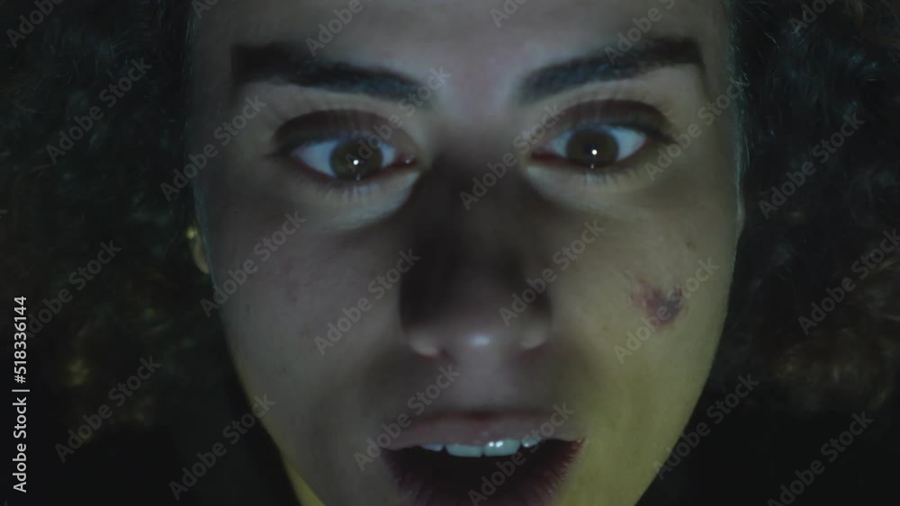 close up portrait of disturbed young woman with wide eyes under a flickering light close up portrait of disturbed young woman with wide eyes under a flickering light