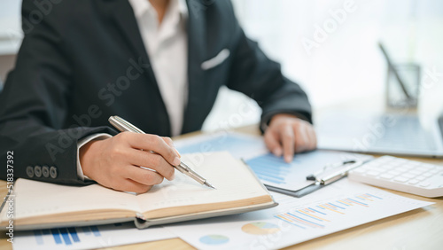 Business woman analyzing data paperwork calculating numbers..