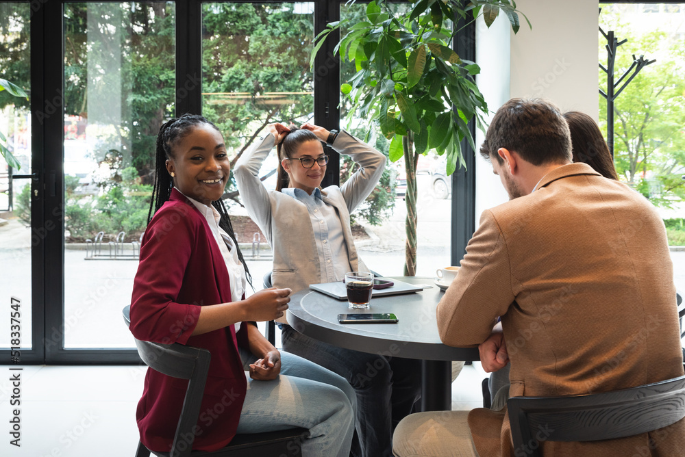 Group of young perspective freelancer business people sitting at cafeteria having meeting about opening private small company as equal partners and to hire young people with ideas for full time work.
