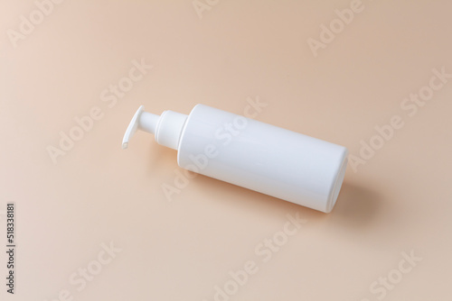 White plasstic bottle isolated on pastel color background, fluid pump container for cosmatic product, flat lay, top view.