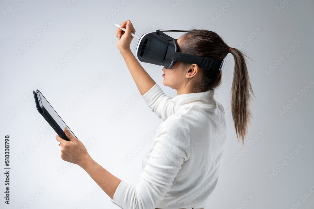 Asian woman wearing VR glasses in studio with white background with using virtual reality headset or VR glass isolate on gray background Asian woman wearing VR glasses in studio with white background with using virtual reality headset or VR glass isolate on gray background
