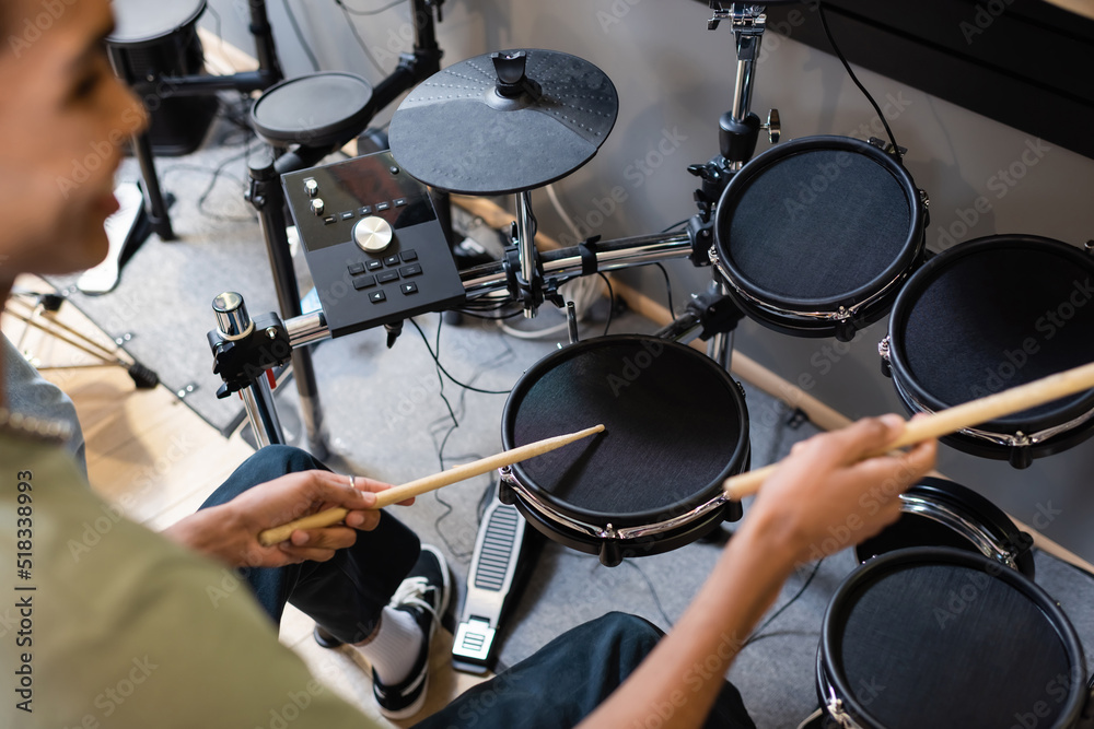Fototapeta premium Blurred african american customer playing electronic drums in music store.