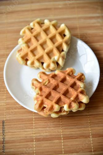 Golden delicious viennese waffles wooden. Wooden background. Raspberry isolated. Gourmet food.