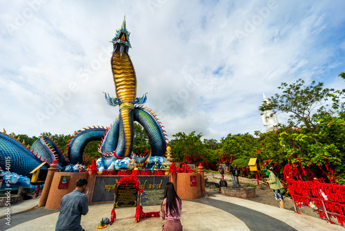 Mukdahan, Thailand, July 5, 2022. Buddhists visit the Statue of Naka and the large Buddha statue Wat Phu Manorom in Mukdahan Province, Thailand. photo