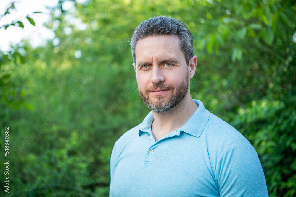 Portrait of handsome man in blue tshirt natural background, copy space