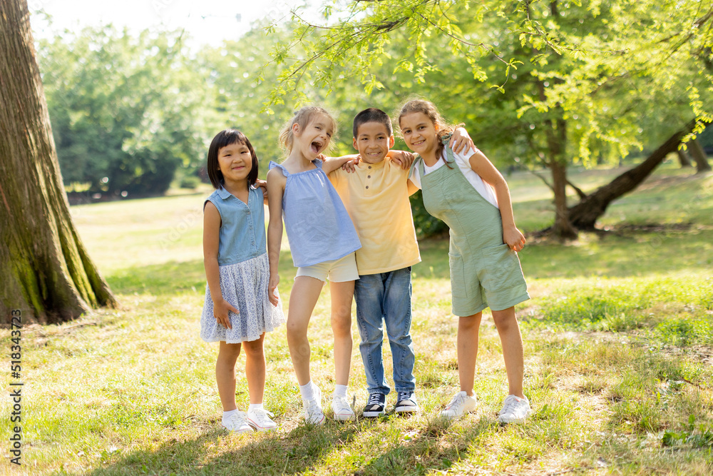 Obraz premium Group of asian and caucasian kids having fun in the park