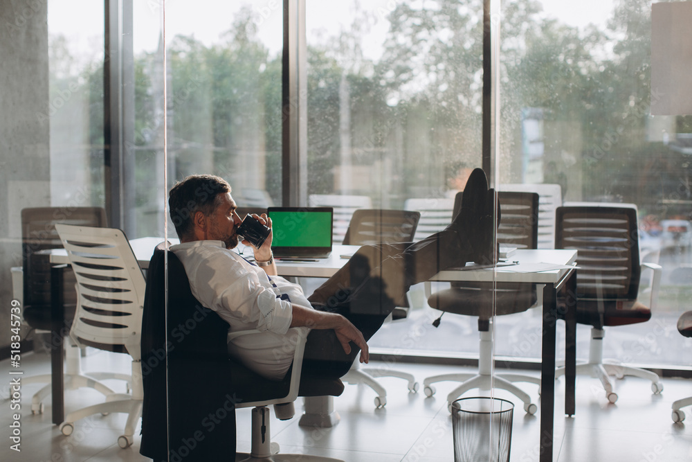 Working overtime in office, tired senior manager satisfied with his work resting in chair after work day.. Working overtime in office, tired senior manager satisfied with his work resting in chair after work day..