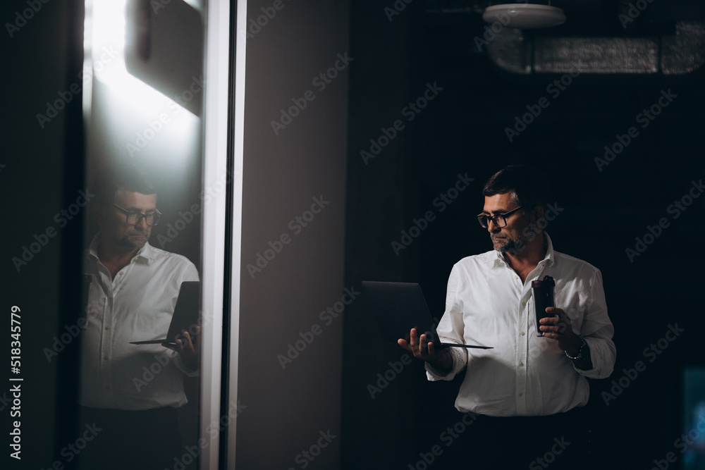 Senior manager alone in the office at night. Senior manager alone in the office at night.