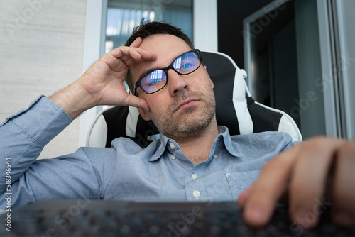uninteresting boring work in the office concept. Sleepy bored man employee sitting at desk has no motivation to work photo