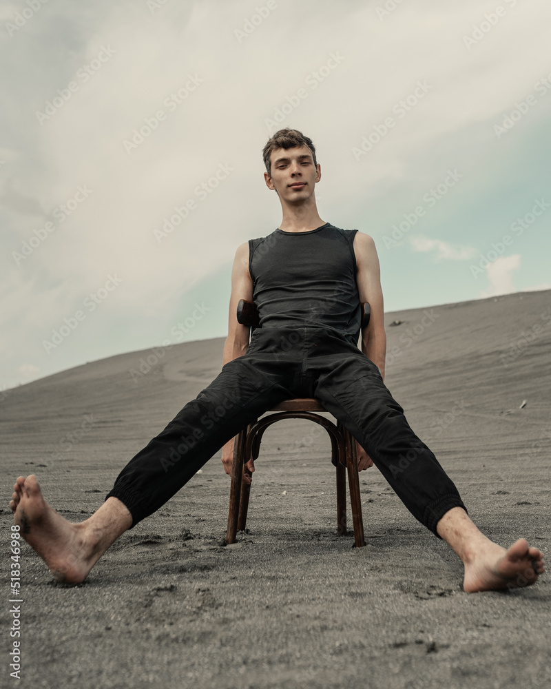 Lone Man sitting on chair in desert Lone Man sitting on chair in desert