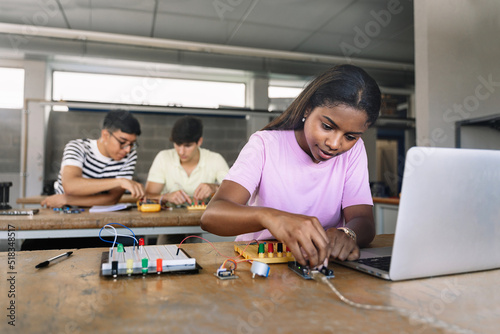 African American High School teenage Student programming electronics circuit board in the science technology workshop - Learning Digital Innovation in Education photo