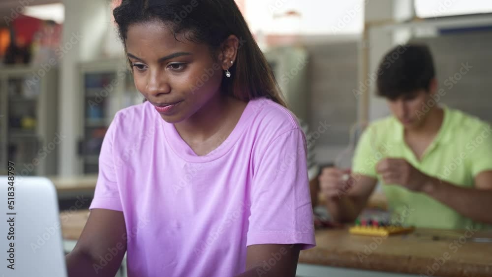 African American High School female teenage Student working with laptop in the science technology workshop