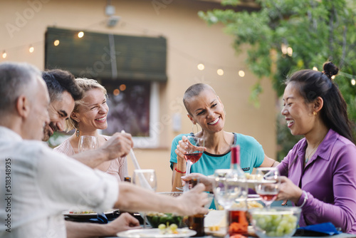 Female friends enjoying healthy food together during summer dinner with friends