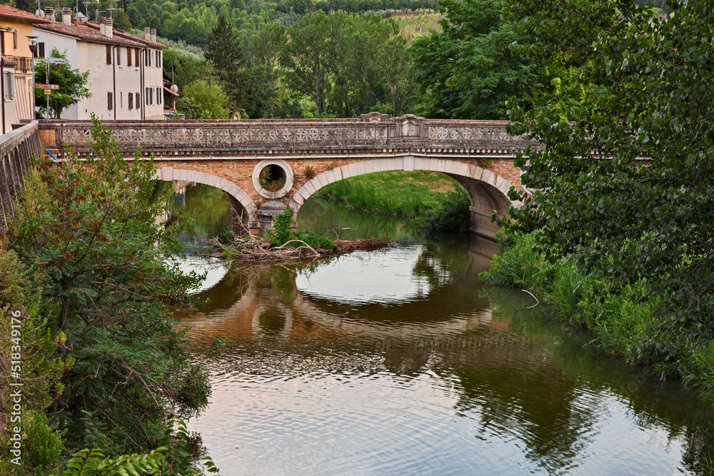 Fiumana, Predappio, Emilia Romagna, Italy - landscape of the village with the river Rabbi and the ancient bridge built in the 20-30s in rationalist architecture