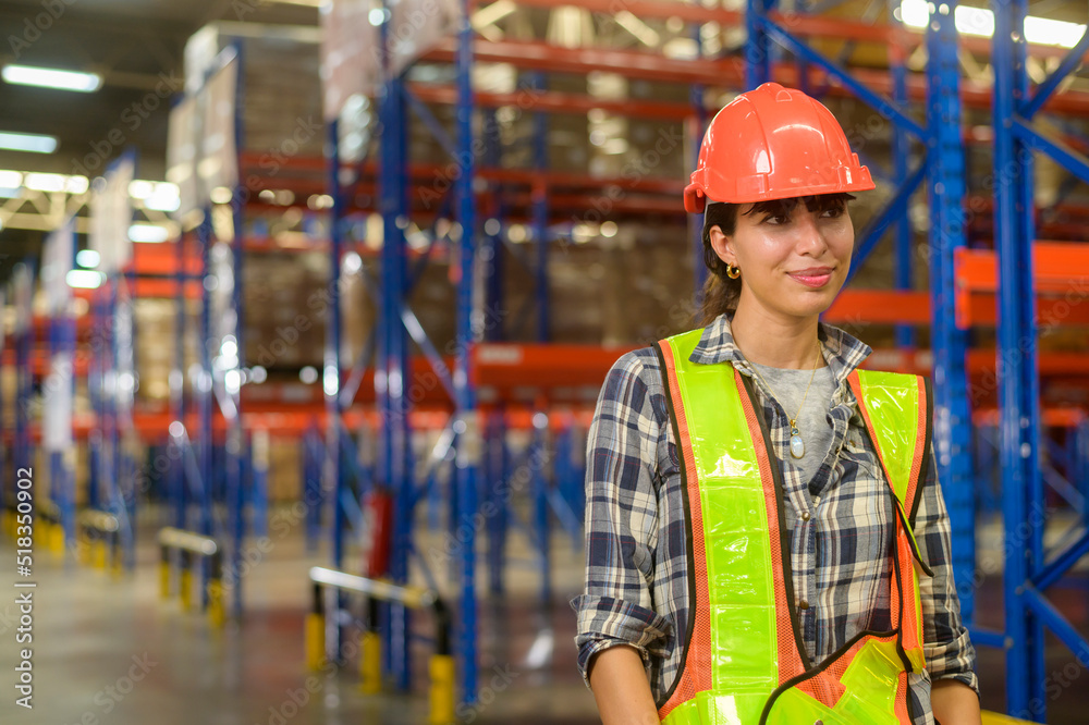 Portrait of young mixed race female worker wearing helmet in modern warehouse storage of retail shop Portrait of young mixed race female worker wearing helmet in modern warehouse storage of retail shop