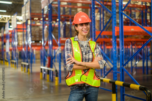 Portrait of young mixed race female worker wearing helmet in modern warehouse storage of retail shop © tonefotografia