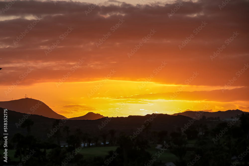 Beautiful colorful sunset sky with silhouette of hills and mountain landscape near Golf del Sur, Tenerife, Canary Islands, Spain, Europe, EU. Vacation vibes on touristic island in Atlantic Ocean