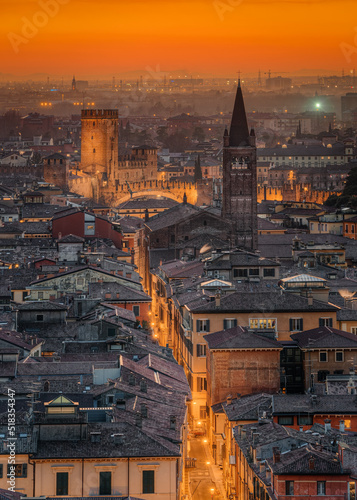View of Verona historic center from Castel Sanpietro, on the Adige river with its curve that contains the ancient city. Sunset in February 2022, visible stone bridge, the basilica of Verona, Santa Ana