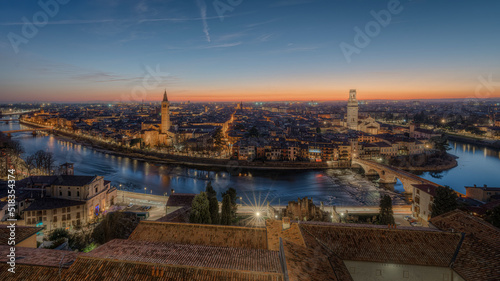 Verona view of Castelvecchio and Ponte Scaligero from San Pietro, February 2022 orange sunset, you can see the church of Santa Eufemia la the illuminated streets of the historic center of Verona.