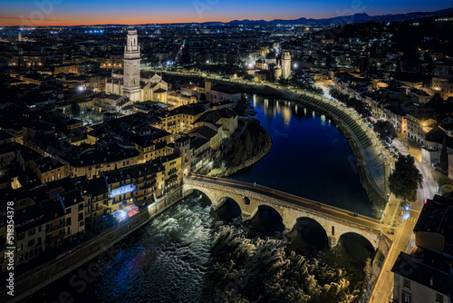 Fly Verona view of Castelvecchio and Ponte Scaligero from San Pietro, February 2022 orange sunset, you can see the church of Santa Eufemia la the illuminated streets of the historic center of Verona.