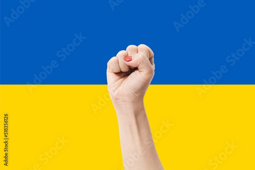 Woman hands with fist gesture on Ukraine flag color background