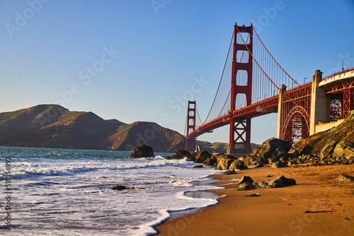 Waves over sandy beaches at Golden Gate Bridge near sunset